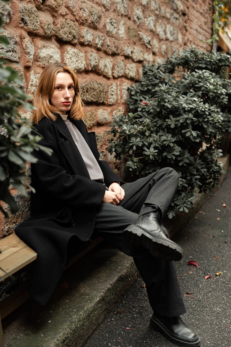 Woman Sitting On A Wooden Bench On A Park