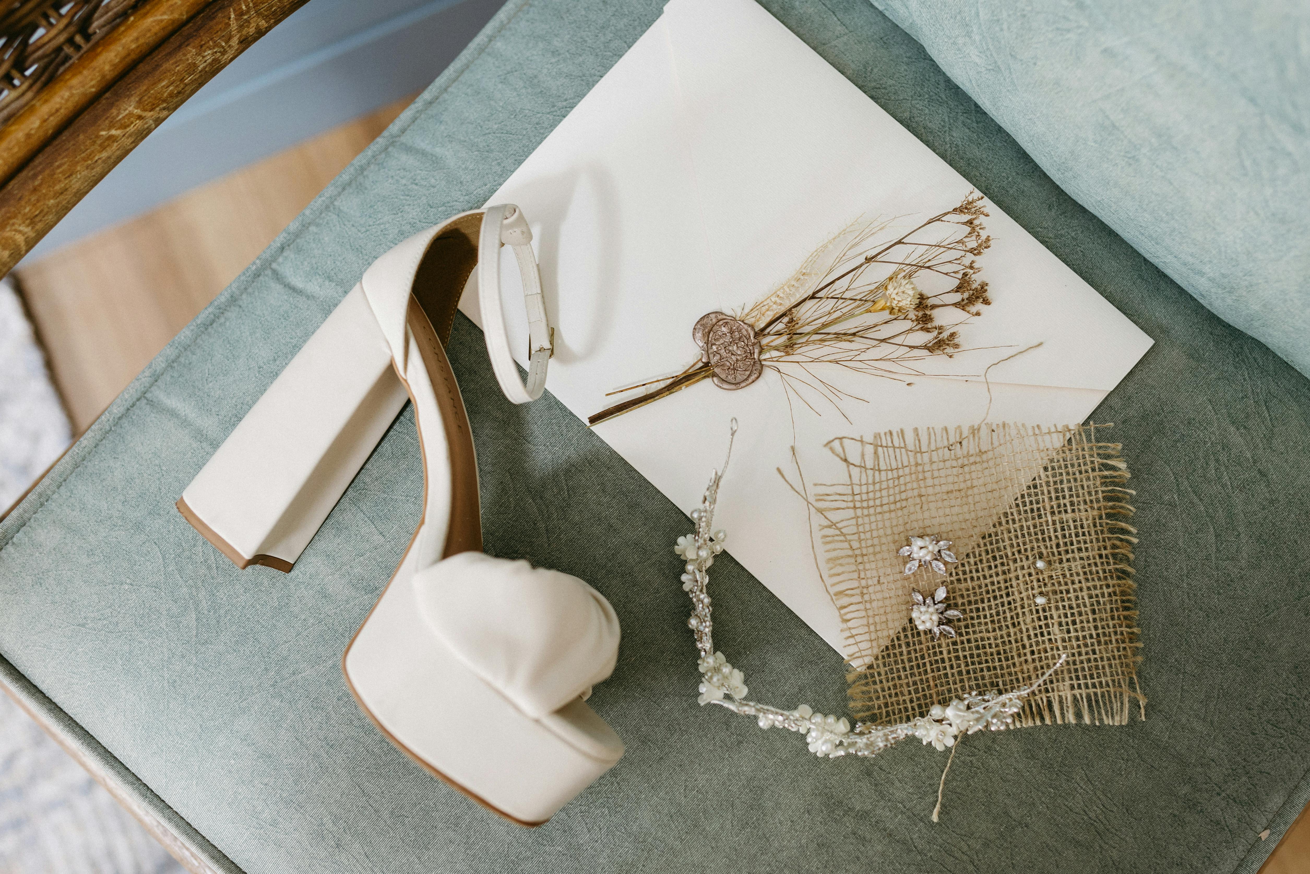 White high heel and delicate accessories on a vintage chair, perfect for a bridal theme.