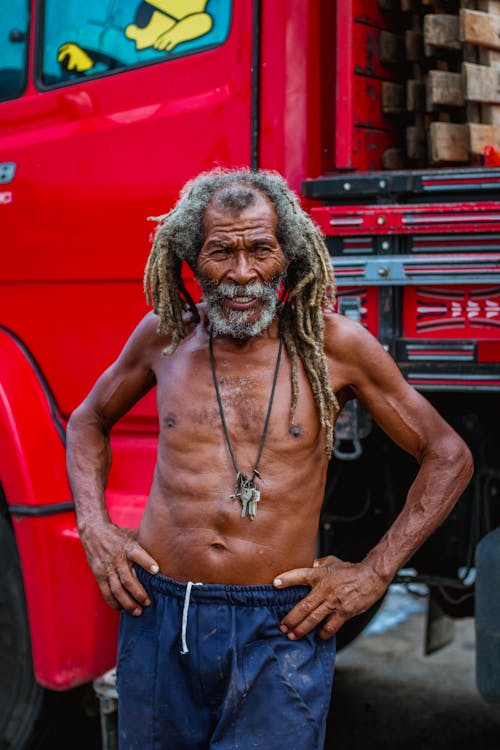 Shirtless Man Standing in front of Truck