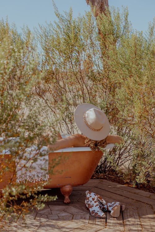 Back View of a Woman in a Hat Lying on a Sun Lounger