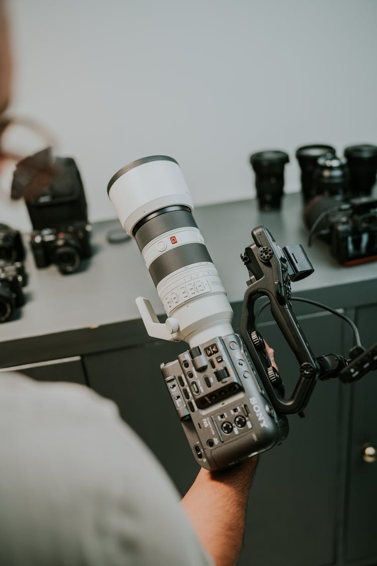 Man Holding A Professional Camera With A Long Lens 