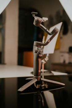 Close-up shot of a professional camera stabilizer on a reflective surface in a studio setting.