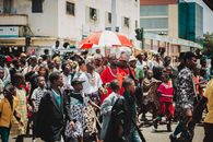 Vibrant street procession in Accra, Ghana showcasing traditional attire and community celebration.
