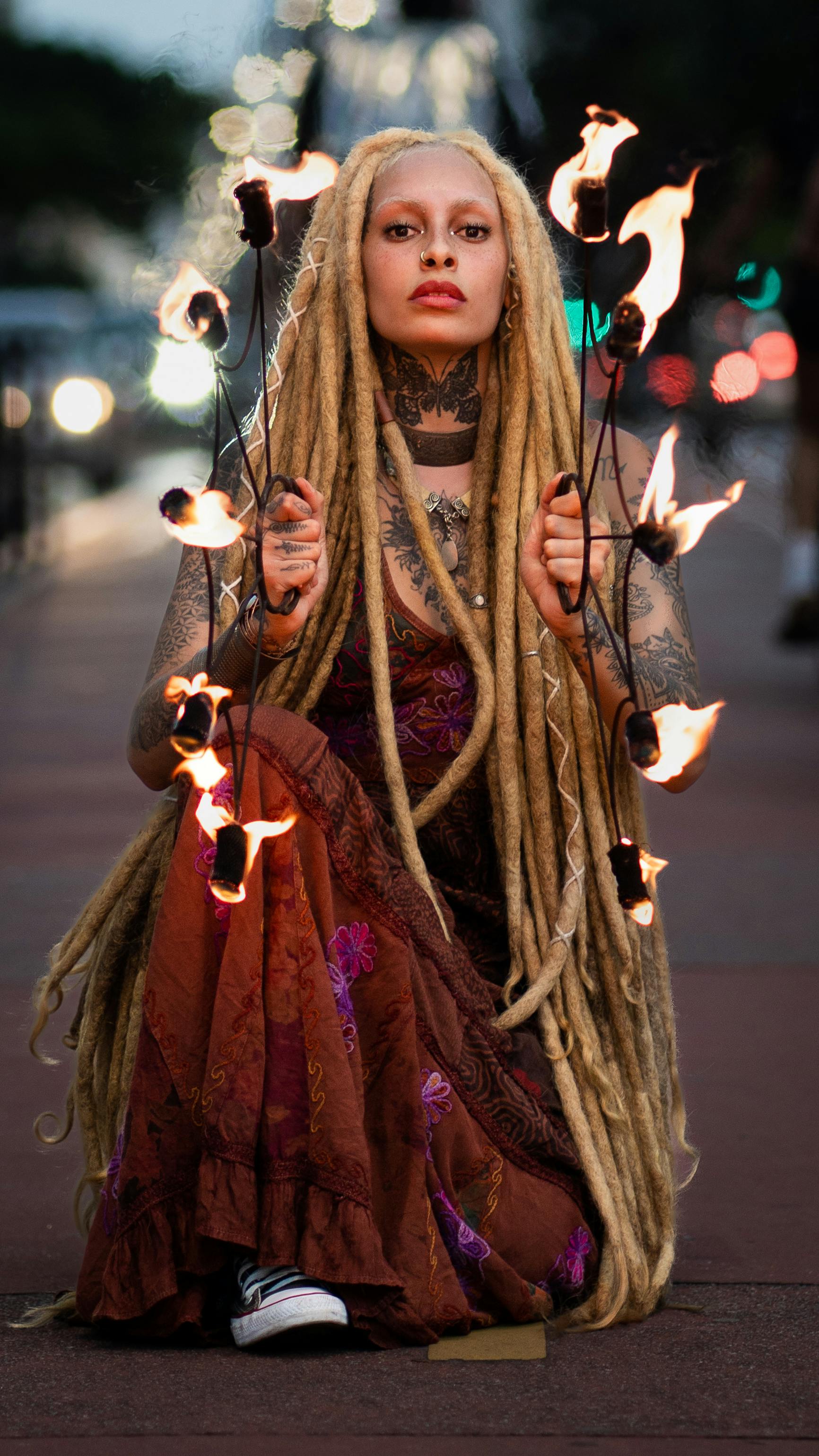 A mesmerizing fire dancer showcasing their talent on city streets at dusk.