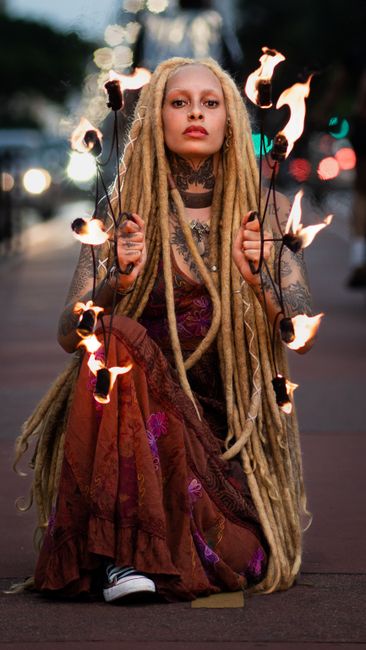 A mesmerizing fire dancer showcasing their talent on city streets at dusk.