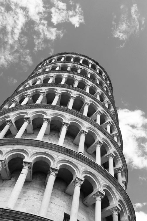 Free Artistic black and white upward view of the Leaning Tower of Pisa against a cloudy sky. Stock Photo