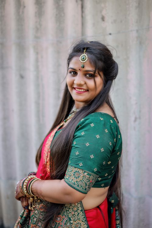 Free Smiling Indian woman in traditional sari and jewelry, posing outdoors, showcasing rich cultural attire. Stock Photo