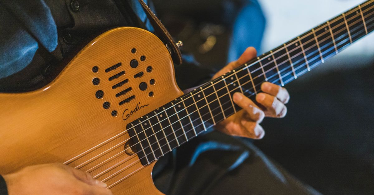 Close-up of a musician's hands on a guitar with holographic AI-generated notes floating around them
