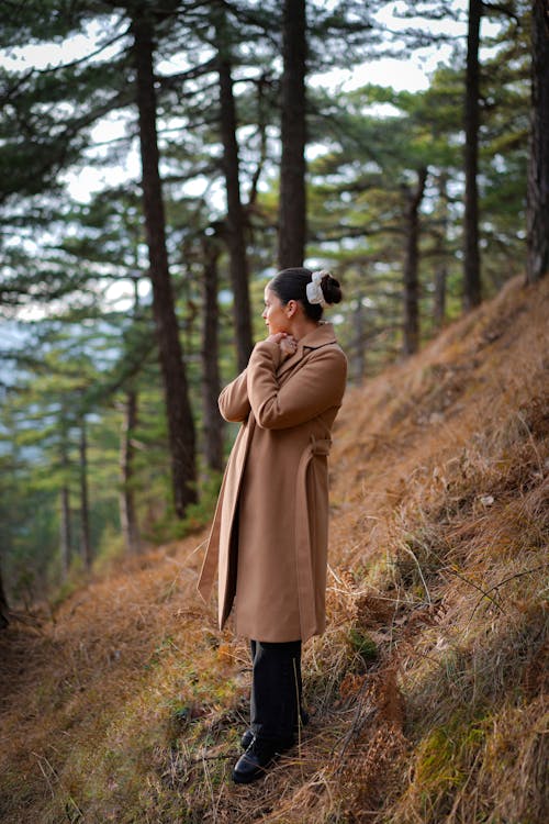 Woman in Coat Standing in Forest