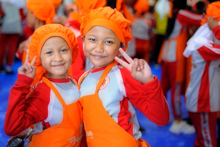 Smiling Girls In Aprons In Hats