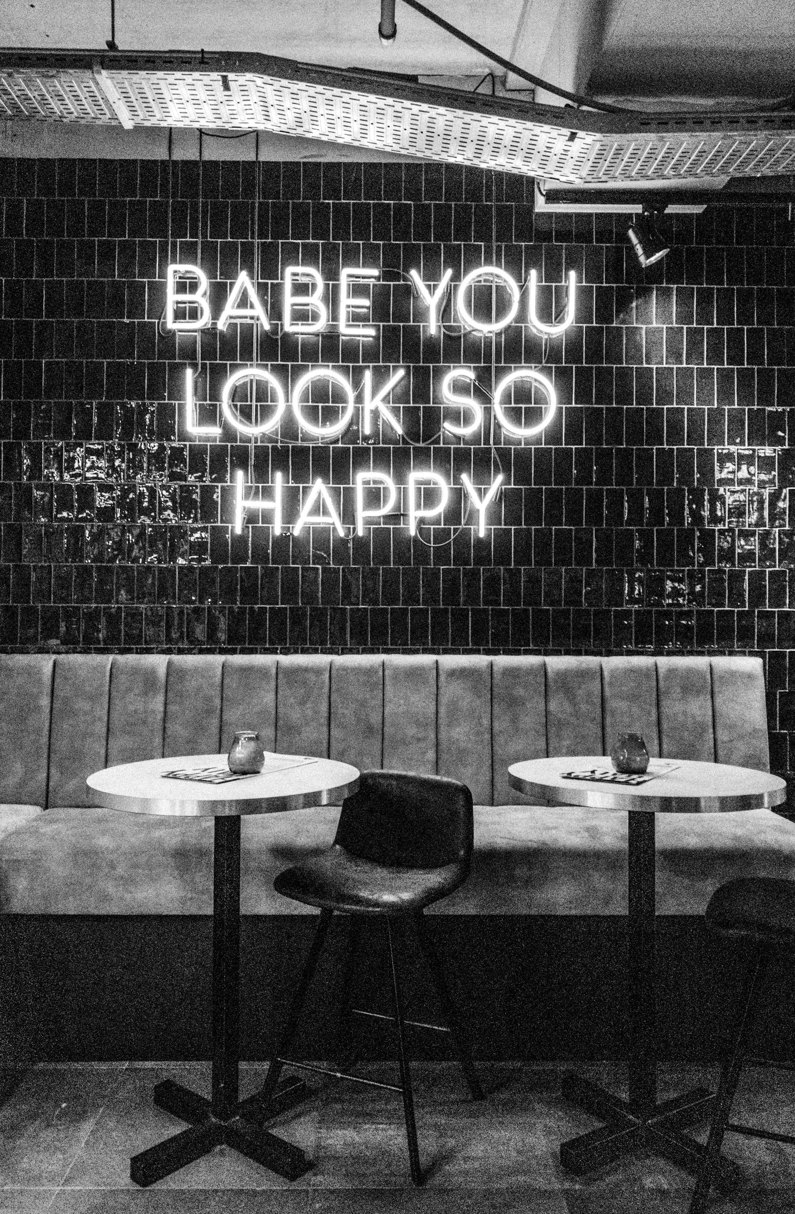 Chic cafe interior featuring a neon sign and modern furnishings.