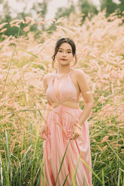 Brunette Wearing a Pink Summer Dress, Posing in Grass