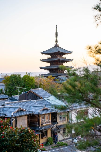 View of Yasaka Pagoda surrounded by traditional Japanese architecture in Kyoto at sunset.