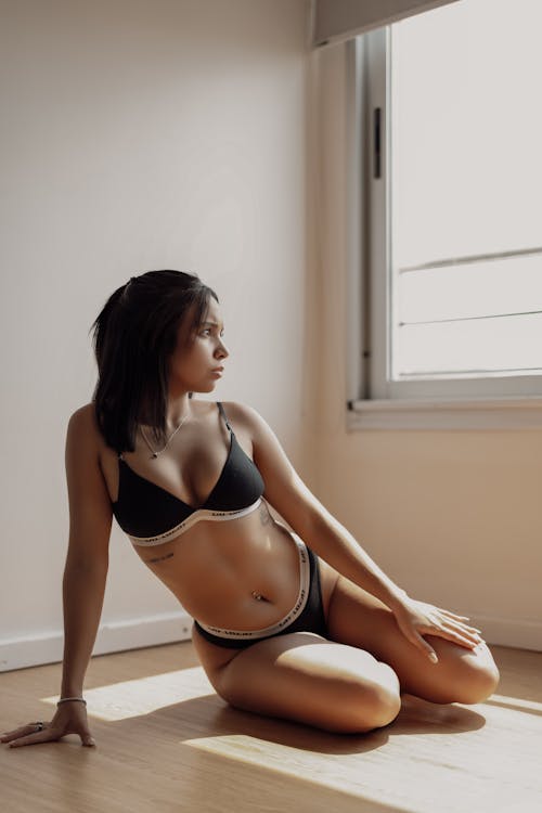 Model in Sports Underwear Sitting on the Floor of an Empty Room