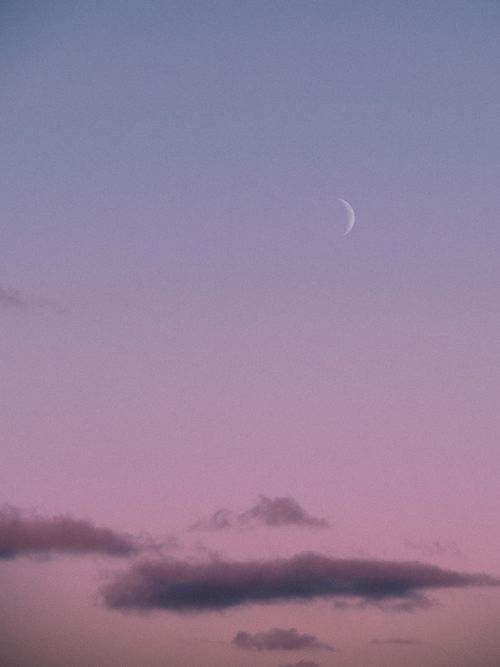 Free A calming pastel sky during dusk featuring a crescent moon and soft clouds. Stock Photo