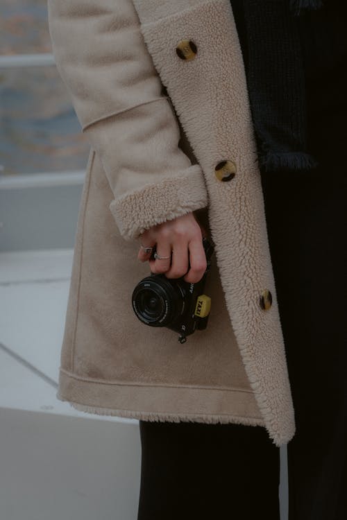 Person in Winter Coat Holding Camera