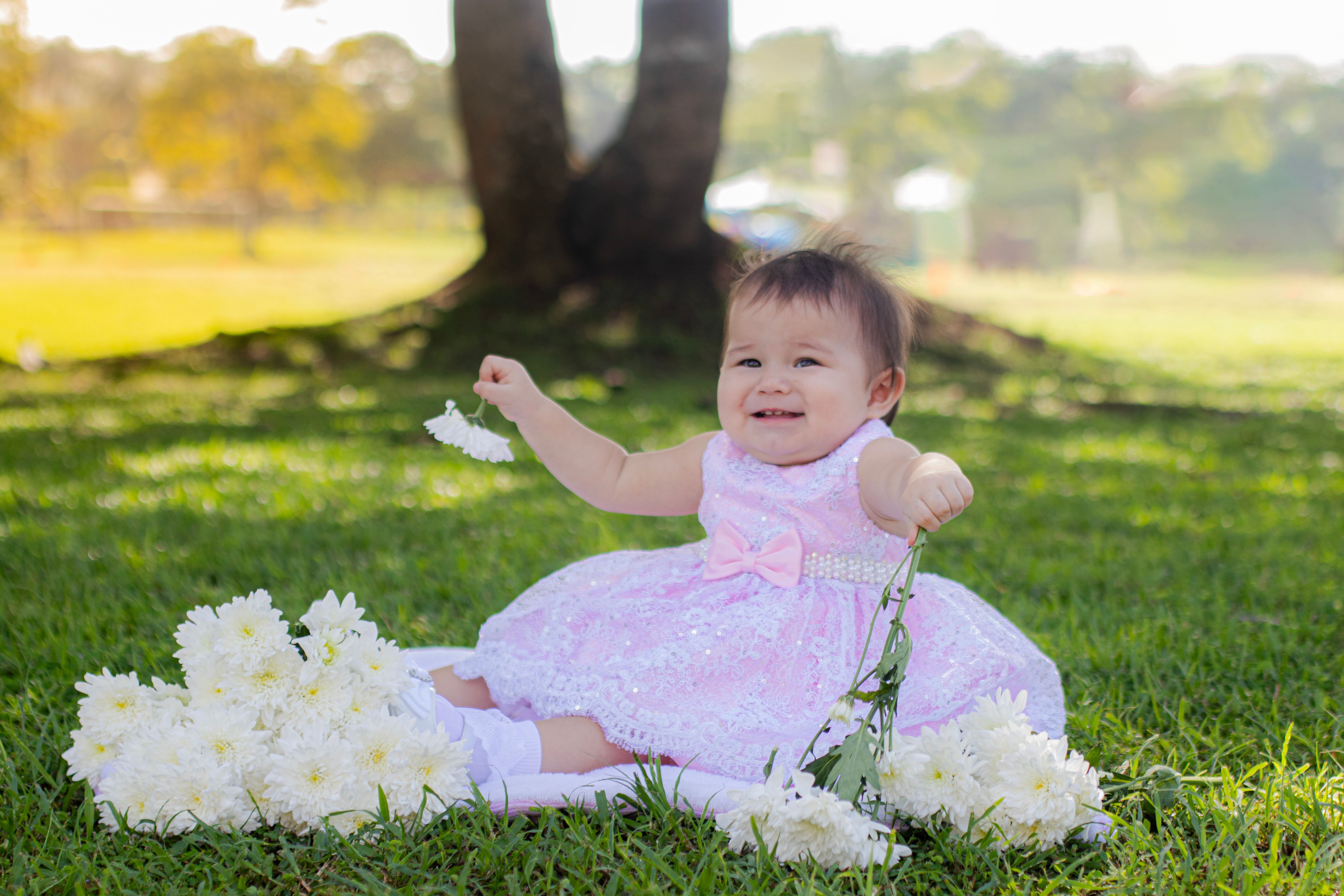 Happy Little Girl in Pink Dress Sitting on Grass · Free Stock Photo