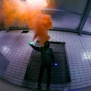 Man Holding Lighted Device over Orange Smoke