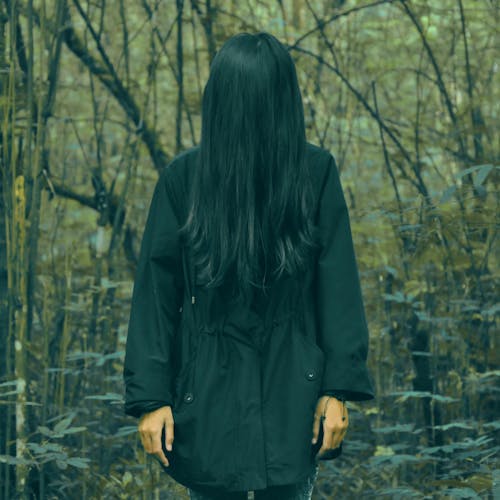 Free Person in Black Coat Standing in Forest Stock Photo