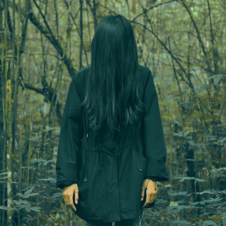 Person In Black Coat Standing In Forest