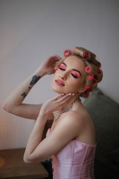 A stylish woman in pink makeup and curlers, exuding retro glamour and elegance in Milan.