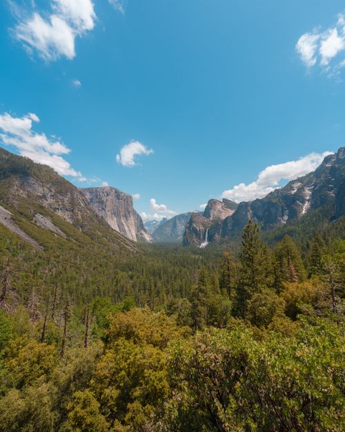 Free Gorgeous aerial shot of Yosemite Valley showcasing lush forests and majestic cliffs under a vibrant blue sky. Stock Photo