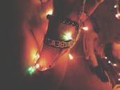 这是一张创意照片，手腕上装饰着手镯，被彩色圣诞灯照亮