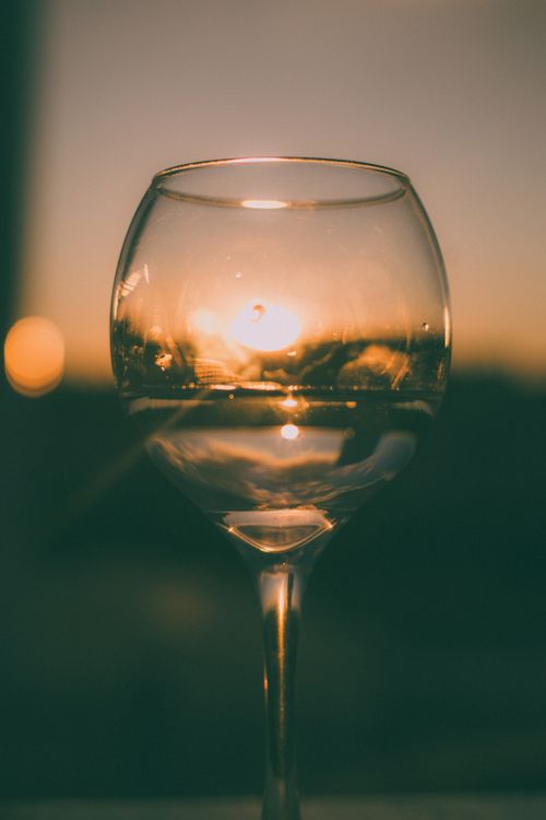 Free A captivating view of the sunset reflected in a wine glass. Perfect for artistic and lifestyle themes. Stock Photo