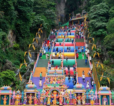 Vibrant stairs leading to Batu Caves in Malaysia with diverse visitors.