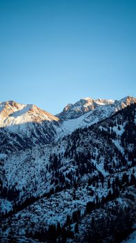 Stunning view of snow-capped mountains under a clear sky in Almaty, Kazakhstan.