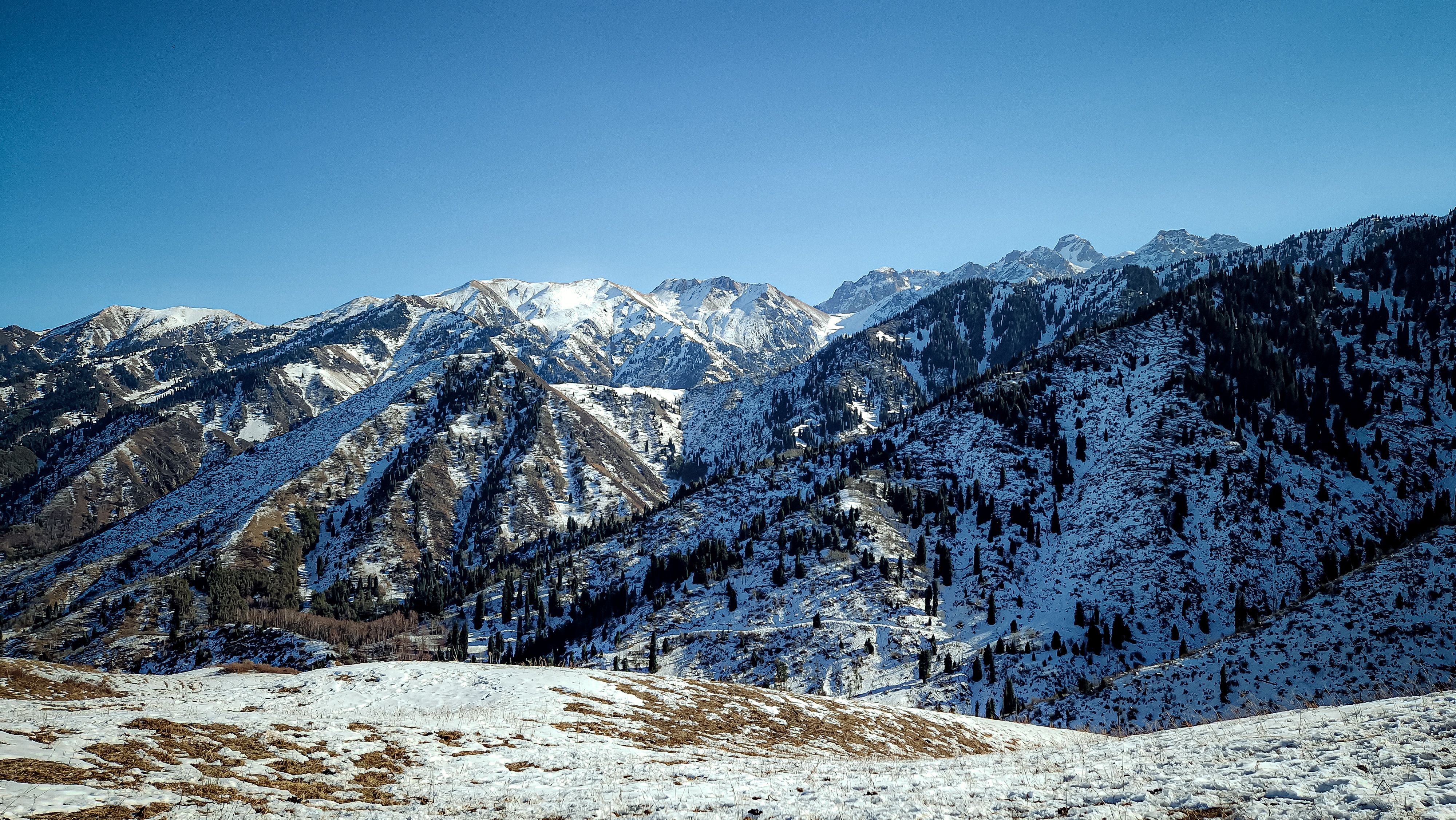 Snowcapped mountain range in Kazakhstan illuminated by alpine sunlight