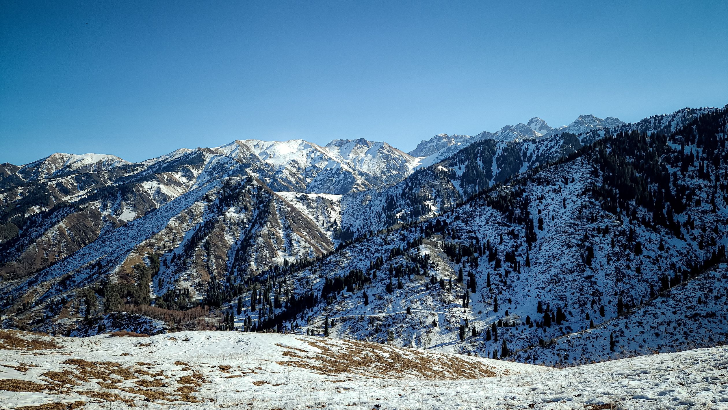Snowcapped mountain range in Kazakhstan illuminated by alpine sunlight