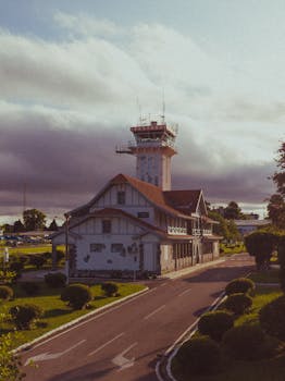 Vintage view of the Bacacheri Airport control tower in Curitiba, Brazil, surrounded by lush greenery.