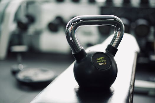 Black kettlebell on gym bench highlighting fitness and strength training equipment.