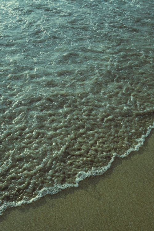 Waves Reaching Wet Sand on Sea Shore