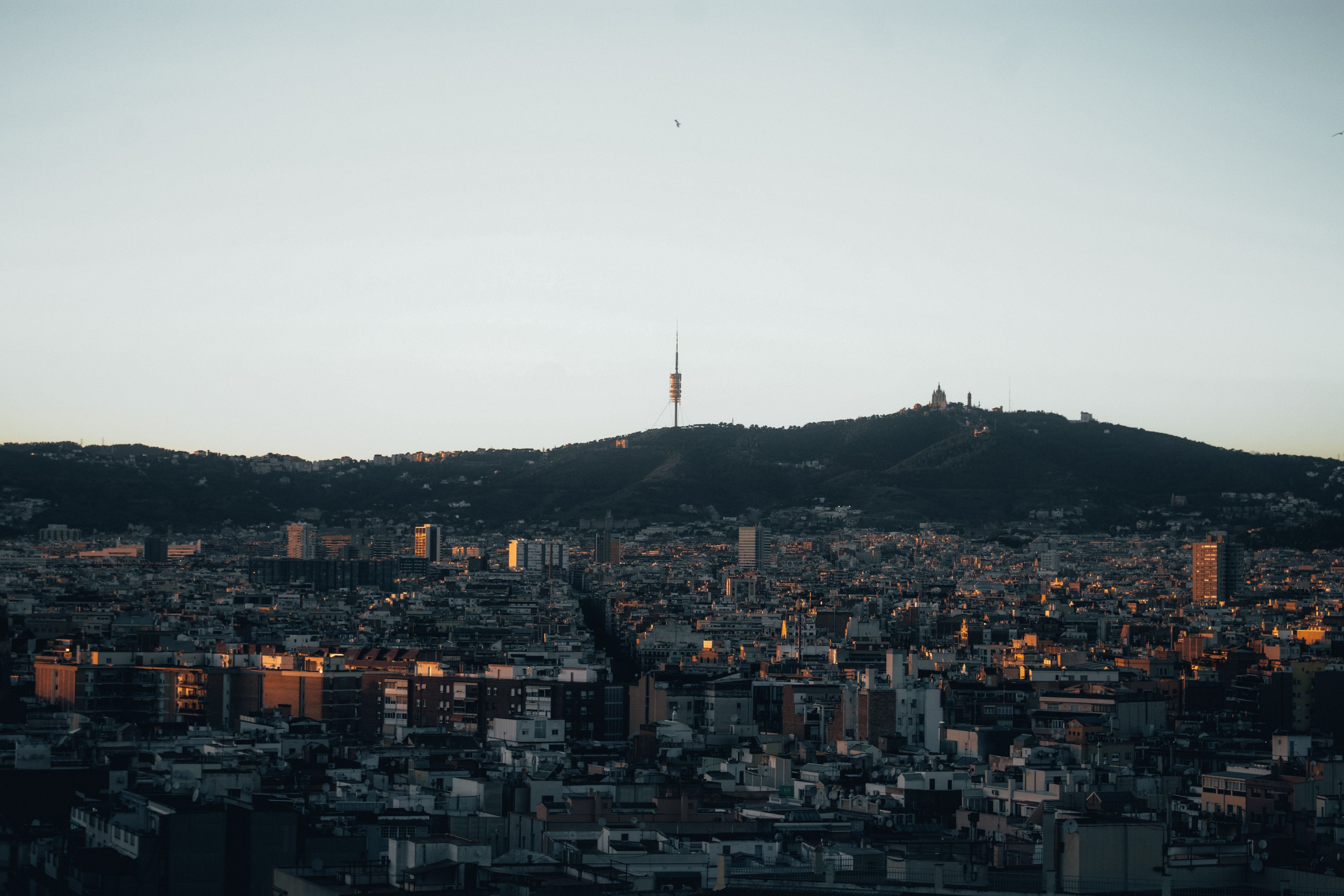 Stunning view of Barcelona with Collserola Tower silhouetted against the evening sky.