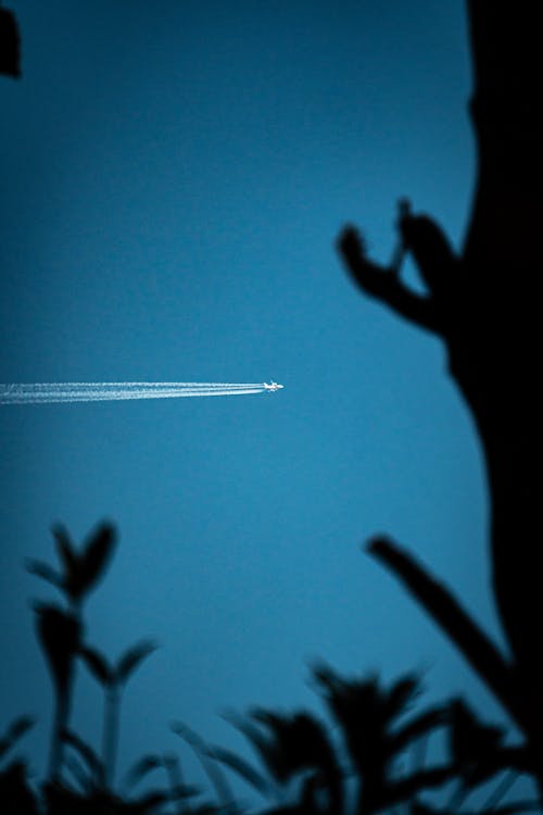 Airplane Leaving Chemtrails in Blue Sky