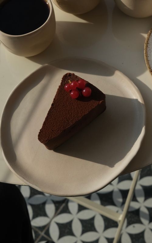 Free Indulge in a rich chocolate cake slice topped with red berries, perfect for dessert lovers. Stock Photo
