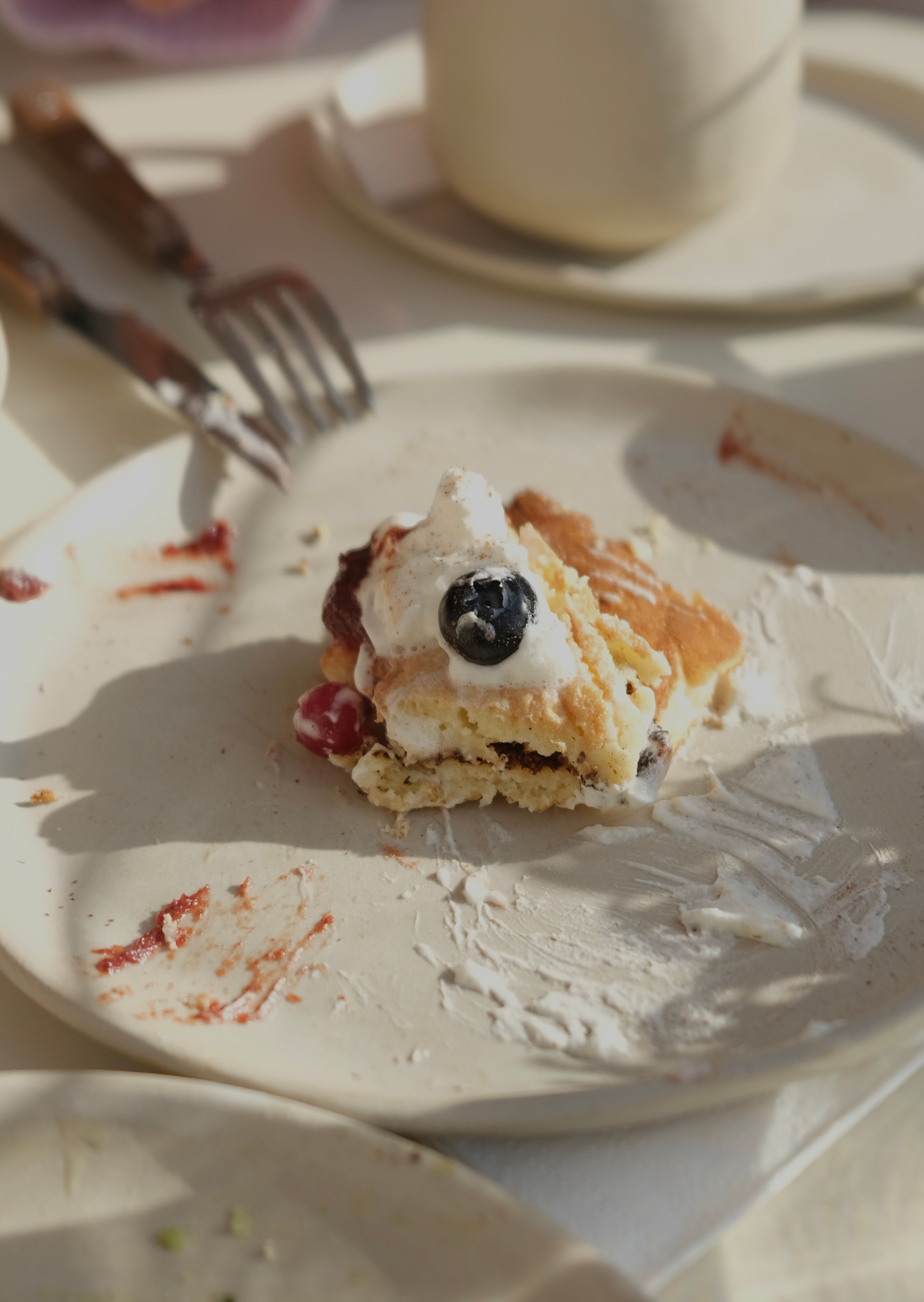 A mouthwatering cake slice on a plate, highlighted by sunlight, capturing a cozy brunch moment.