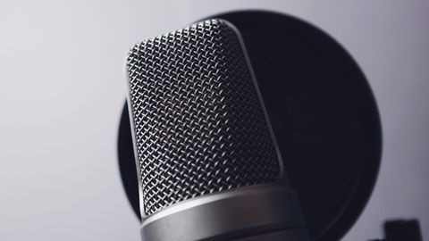 A close-up of a professional microphone in a studio. Ideal for music and broadcasting themes.