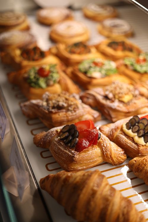Free A variety of savory and sweet pastries elegantly displayed in a bakery showcase, showcasing croissants and puff pastry delights. Stock Photo