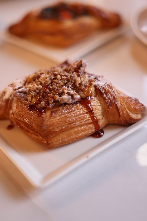 Free A close-up of a cinnamon puff pastry topped with nuts and syrup, perfect for breakfast or a sweet treat. Stock Photo