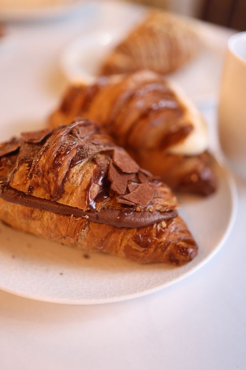 Free Close-up of a chocolate-covered croissant on a plate, perfect for food photography. Stock Photo