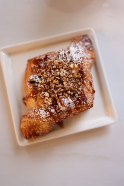Free Close-up of a freshly baked pastry topped with nuts and powdered sugar. Stock Photo