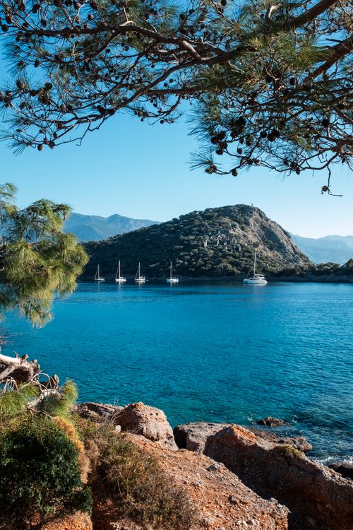 Free Beautiful seaside scene in Fethiye, Türkiye with sailboats and rocky shore. Stock Photo