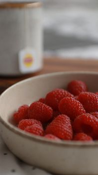 Close-up shot of fresh raspberries in a ceramic bowl, perfect for food photography.