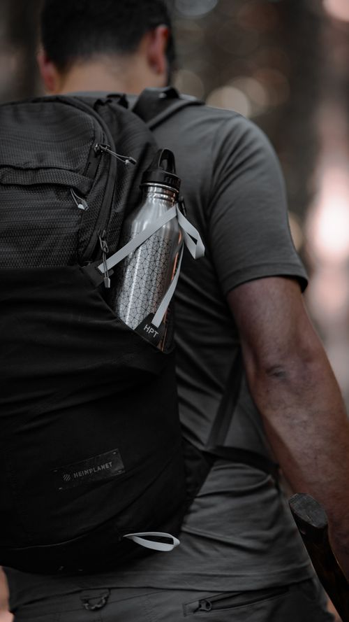 Free Back view of a man hiking in İstanbul, carrying a backpack with a bottle. Adventure spirit. Stock Photo