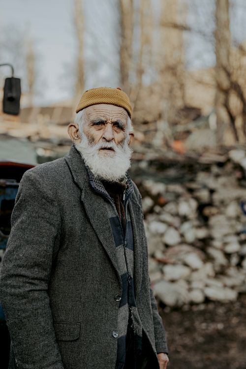 Free Portrait of an elderly man in a wool coat and hat, standing outdoors in Sivas, Türkiye Stock Photo