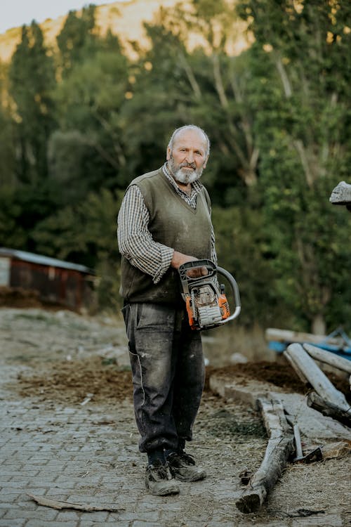 Senior Man Holding a Chainsaw