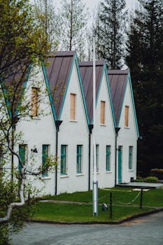 A row of charming Scandinavian style houses with green roofs and lush surroundings.